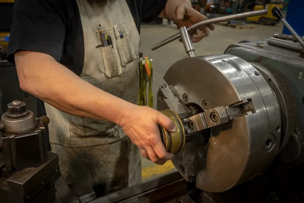 Man repairing cylinder with a machine